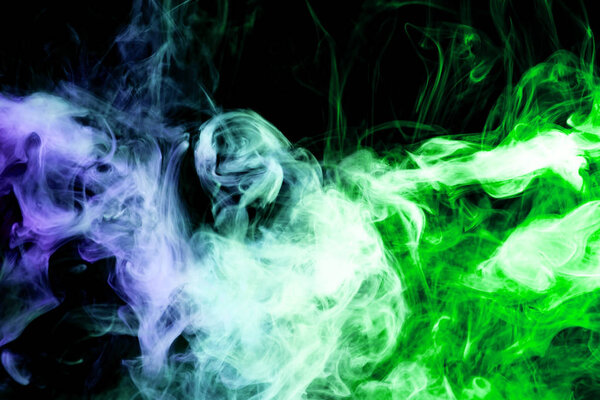 Thick colorful smoke of blue and green on a black isolated background. Background from the smoke of vape