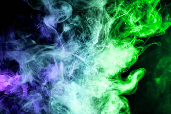 Colorful green and blue smoke on a black isolated background. Background from the smoke of vap