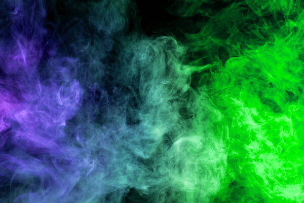 Dense multicolored smoke of blue and green colors on a black isolated background. Background of smoke vap