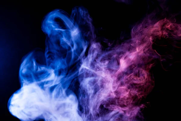Blue and purple cloud of smoke of  black isolated background. Background from the smoke of vap