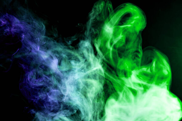 Blue and green cloud of smoke of black isolated background. Background from the smoke of vap