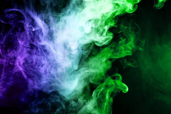 Blue and green cloud of smoke of black isolated background. Background from the smoke of vap