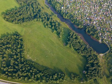 Bir sıcak, güneşli yaz gününde küçük bir köy, küçük bir göl, bir yeşil orman ve büyük bir alanı yukarıdan görünüm