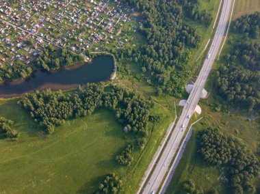 Üstten görünüm küçük evleri,, yeşil orman ve bir sıcak güneşli yaz günü büyük bir alanda büyük bir köy. Helikopter dron vurdu.