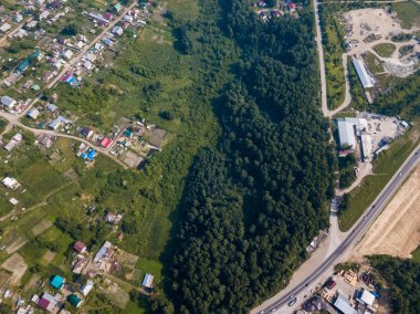 Yaz günü küçük evler, yeşil orman ve bir sıcak, güneşli büyük bir alanda büyük bir köye bir quadrocopter fotoğraf çekimi