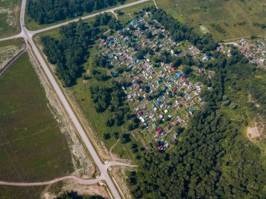 Yaz günü küçük evler, yeşil orman ve bir sıcak, güneşli büyük bir alanda büyük bir köye bir quadrocopter fotoğraf çekimi