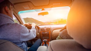 Bir araba bir gezi dağlara sürme aşık genç bir çiftin yakın çekim. Arka görünüm portre adamın maceraları için bir araba sürücüsüne yayılıyor. Yaşam tarzı ve seyahat kavramı.