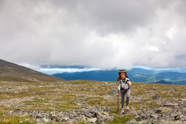 Atmosferik an dağlarda. Sırt çantası gezgin dağlar üstüne kadınla hiking. Hiking, arka planda yeşil orman, alan ve yüksek dağlar şık kadın. Seyahat yaşam tarzı ve yaşam kavramı arka vie