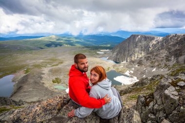 Atmosferik an için dağlarda aşık. Hiking kadın ve adam montaj üstüne oturan ve güzel bir manzaraya bakarak. Yaşam tarzı ve yaşam kavramı arka profili seyahat