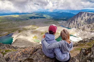 Atmosferik an için dağlarda aşık. Kadın ve montaj üstünde duran ve güzel bir manzaraya bakarak adam hiking. Yaşam tarzı ve yaşam kavramı arka profili seyahat