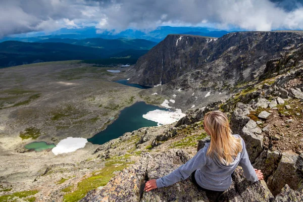 Woman hiker enjoy the view at sunset mountain peak cliff.  Stylish woman hiking. Travel Lifestyle and survival concept rear vie