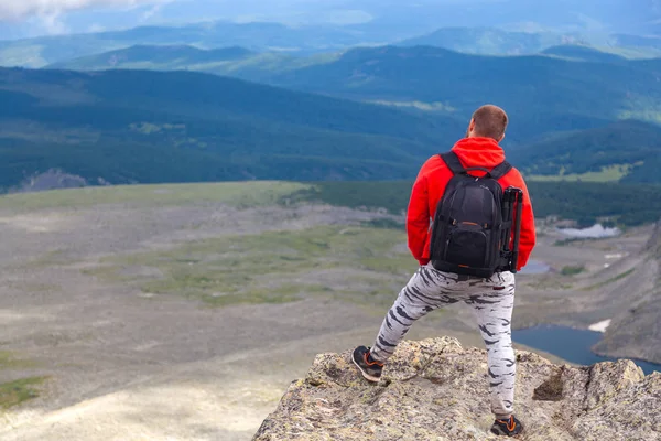 Man hiker enjoy the view at sunset mountain peak cliff.Photographer traveler on  high mountaint  Stylish man hiking. Travel Lifestyle and survival concept rear view