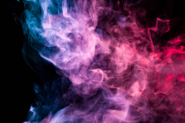 Colorful pink, blue and red smoke on a black isolated background. Background from the smoke of vap
