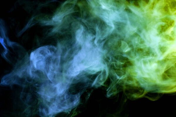 Green and blue cloud of smoke of black isolated background. Background from the smoke of vap