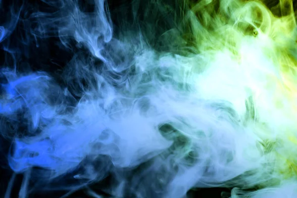 Green and blue cloud of smoke of  black isolated background. Background from the smoke of vap