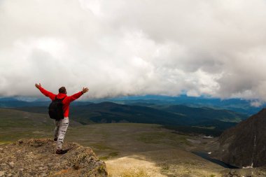 Adam uzun yürüyüşe çıkan kimse günbatımı dağ tepe cliff manzaraya tadını çıkarın. Fotoğrafçı gezgin yüksek mountaint şık adam hiking. Yaşam tarzı ve yaşam kavramı arka profili seyahat