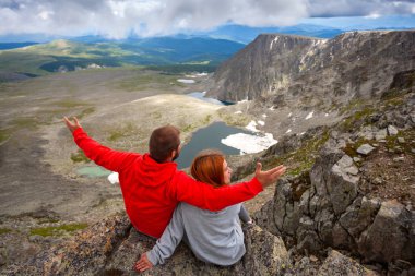 Atmosferik an için dağlarda aşık. Kadın ve montaj üstünde duran ve güzel bir manzaraya bakarak adam hiking. Yaşam tarzı ve yaşam kavramı arka profili seyahat