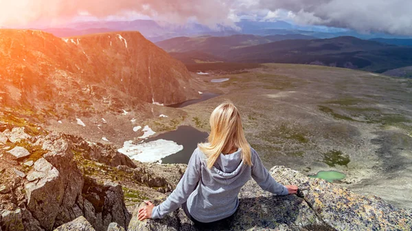 Woman hiker enjoy the view at sunset mountain peak cliff.  Stylish woman hiking. Travel Lifestyle and survival concept rear vie