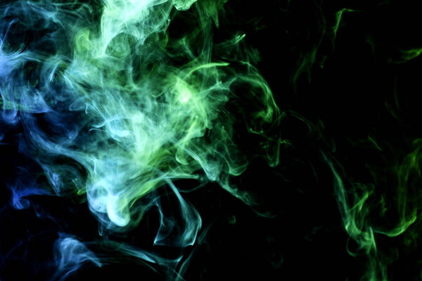 Dense green and blue smoke on a black isolated background. Background of smoke vap