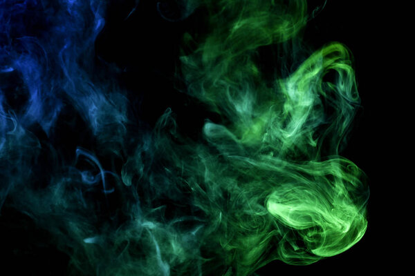 Green and blue smoke on black backgroun