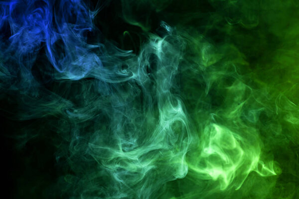 Cloud of blue and green smoke on a black isolated background. Background from the smoke of vap