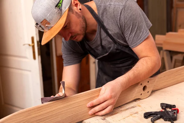 Experienced carpenter in work clothes and small buiness owner working in woodwork workshop, using sandpaper for polishing children's helicopter blades at worktable in workshop — Stock Image Experienced Carpenter Work Clothes Small Buiness Owner Working Woodwork Workshop Royalty Free Stock Images
