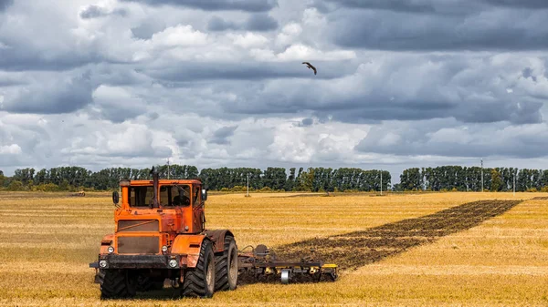 Ein Oranger Moderner Traktor Pflügt Die Erde — Stockfoto