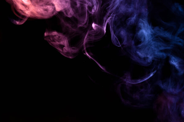 Thick blue,pink and purple smoke on a black isolated background. Background from the smoke of vap