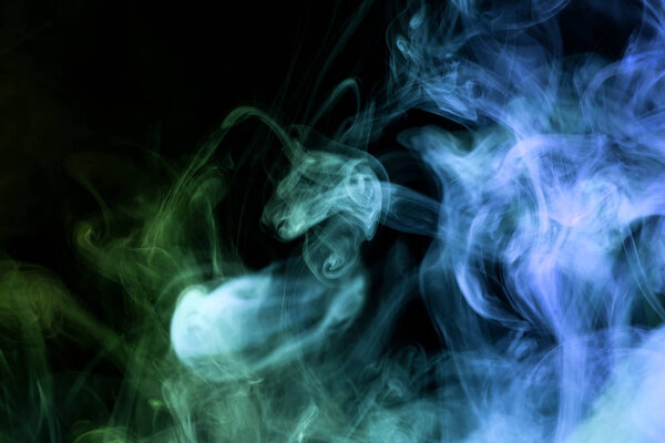 Thick blue and green smoke on a black isolated background. Background from the smoke of vap