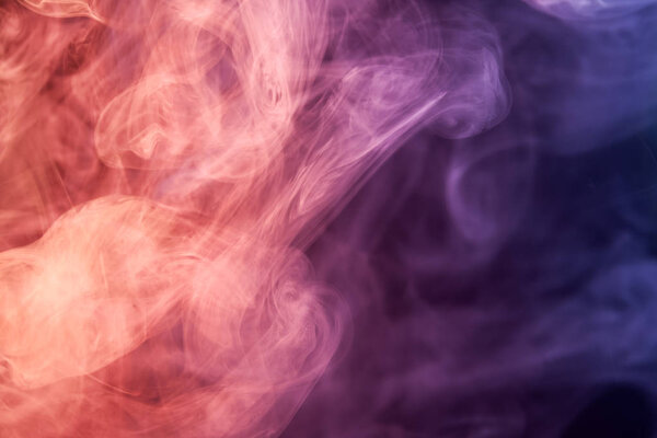 Red, pink and purple cloud of smoke of black isolated background. Background from the smoke of vap