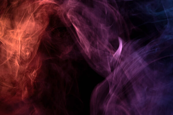 Thick red, pink and blue smoke on a black isolated background. Background from the smoke of vap