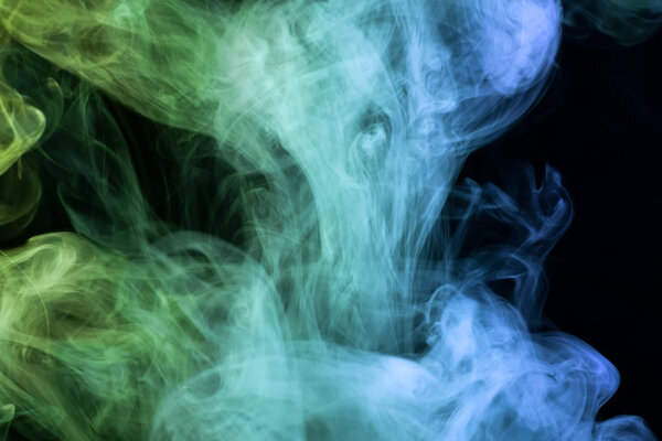 Green and blue smoke on black backgroun