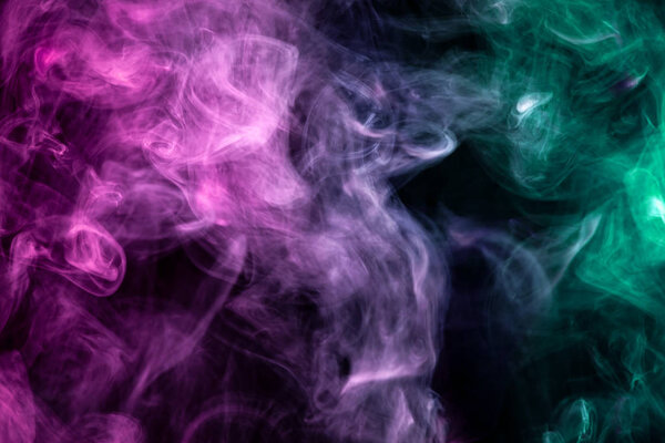Colorful pink and green smoke on a black isolated background. Background from the smoke of vap