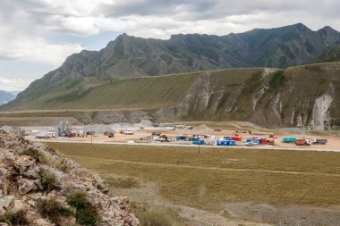 Endüstriyel bir tesisi dağlarda büyük ölçekli inşaat Vinçler, kamyon ve diğer özel ekipman mavi gökyüzüne karşı yardımı ile panoramik manzaralı