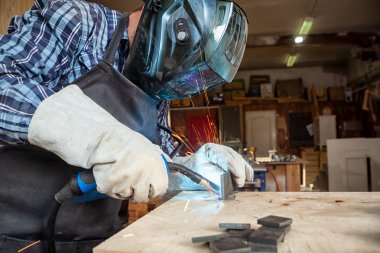 Güçlü adam kaynakçı giyim zor çalışma ve kaynak bir kaynak makine metal ile yakın çekim