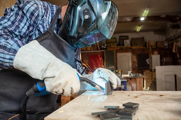 Güçlü adam kaynakçı giyim zor çalışma ve kaynak bir kaynak makine metal ile yakın çekim