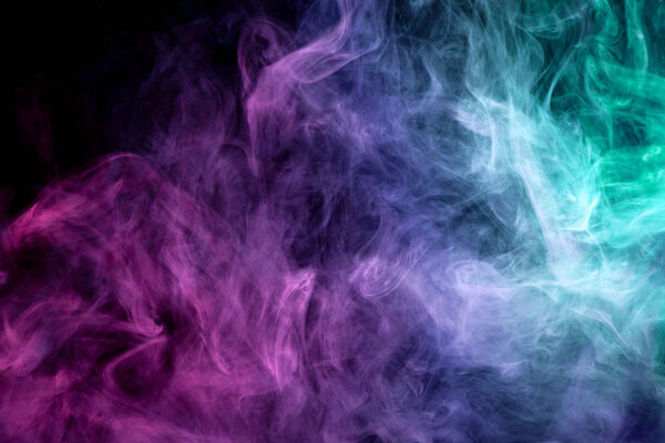 Colorful pink, blue and green smoke on a black isolated background. Background from the smoke of vap