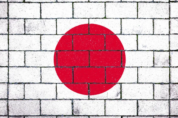 National flag of  Japan against a background of a stone background covered with moss