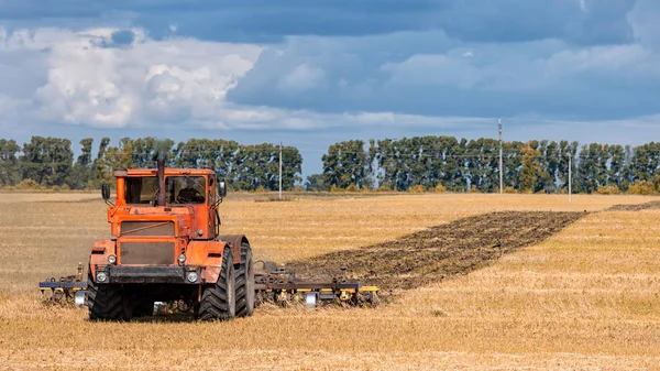 Ein Oranger Moderner Traktor Pflügt Die Erde — Stockfoto