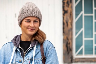 Deniz feneri arka plan üzerinde poz kahverengi örgü şapka ve denim ceket giyen muhteşem darkhaired kadın