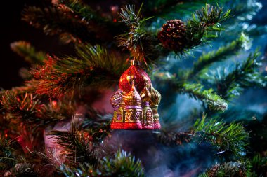 Kırmızı parlak dekorasyon Noel topları Kremlin ile evde mor-kırmızı renkli duman, bir Noel ağacı arka plan üzerinde. Modern bir Noel kartı kavramı. 