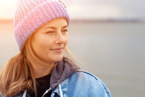 幸せな美しい若い女性青のニット帽子とデニム コートで笑顔 晴れた秋の日に 屋外でポーズのクローズ アップ — ストック写真
