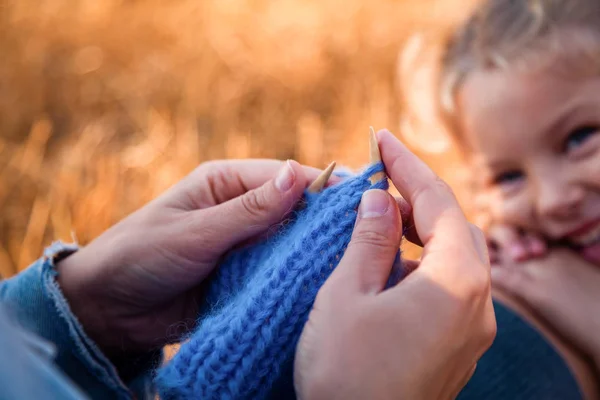 Livestyle と家族の屋外のレクリエーションの概念 若い女性の娘少女背景に自然なウールで作られた青い帽子彼女の編み物編み物時計動作の母 — ストック写真