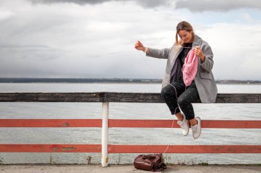 Güneşli bir sonbahar günde deniz arka planı pembe doğal yün şapka örgü şık giysiler içinde genç kadın portre. Serbest yaratıcı çalışma ve yaşam kavramı