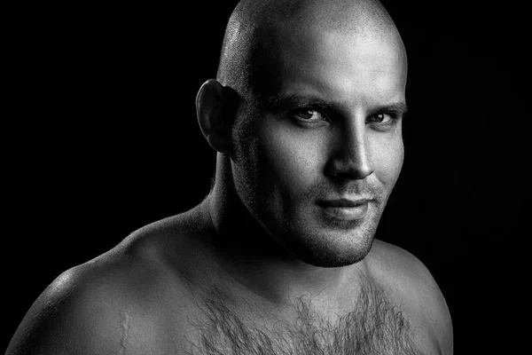 Smiling  young bald man standing isolated on a black background and looking at camera. Portrait Handsome man with confident face in studio