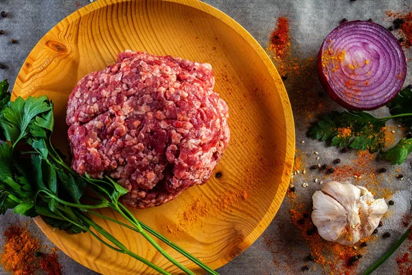 Flat lay. A set of fresh ingredients  for cooking ground beef:beef meat, onion, garlic, tomato, spices, salt, pepper, greenery. The process of cooking meatballs, hamburger, lasagna and other meat dishes