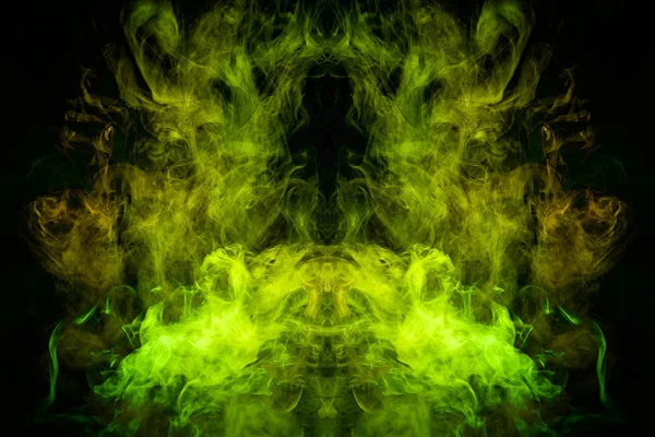 Fantasy print for clothes: t-shirts, sweatshirts. Thick colorful smoke of yellow, green colors smoke in the form of a skull, monster, dragon on a black isolated background. Background from the smoke of vap