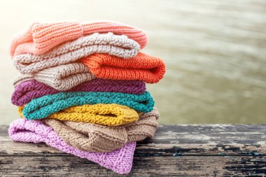 Satır Satılık doğal arka plan üzerinde renkli örgü şapkalar. Bobble şapka dizilmiş renkli topluluğu