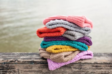 Satır Satılık doğal arka plan üzerinde renkli örgü şapkalar. Bobble şapka dizilmiş renkli topluluğu