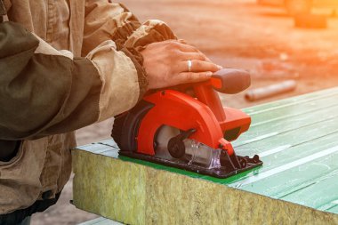 Bir genç adam Oluşturucusu'nda çalışan bir genel inşaat yan bir açı değirmeni ile bir sandviç panel biler